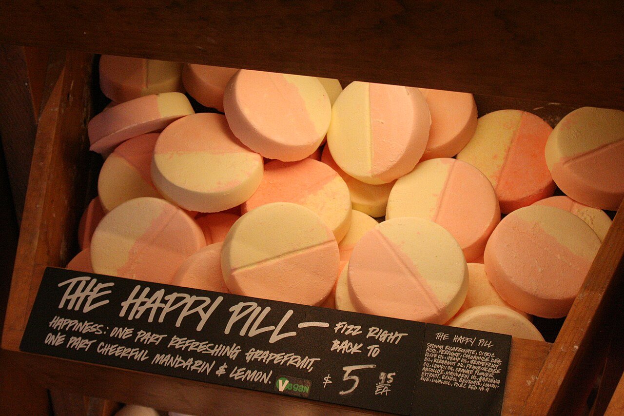 Lush bath bombs called The Happy Pill, with a hand-lettered chalkboard label